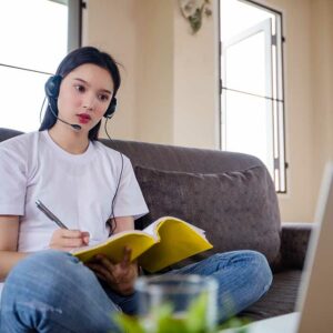 Asian happy woman student wear headphones study online watching