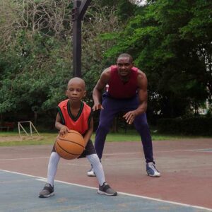 Father training son in basketball